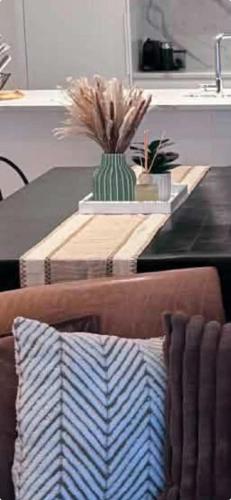 a coffee table with a vase on top of a couch at Beach Getaway in Mount Maunganui