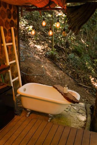 a bath tub sitting on a deck with lights at Tree House in Vítor Hugo