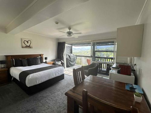 a bedroom with a bed and a table with a dining room at Coromandel Seaview Motel in Coromandel Town