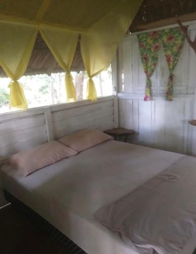 a large bed in a room with windows at A Casa Da Ilha Cotijuba in Belém