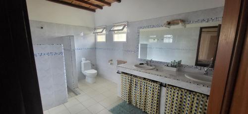 a bathroom with a sink and a toilet and a mirror at Belle maison dans résidence avec piscine in Cap Skirring