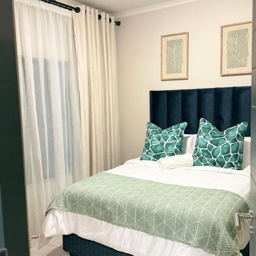 a bedroom with a bed with a blue headboard at Kurhula nest in Midrand