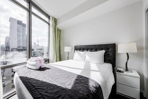 a bedroom with a bed and a large window at Adelaide Stays and Suites - Walk to Subway - Easy Access Downtown Toronto in Vaughan