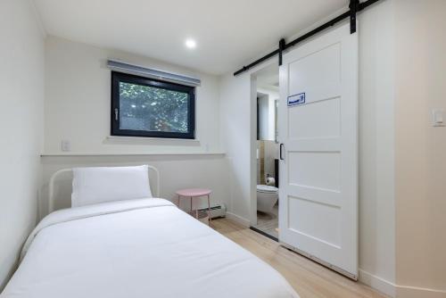 a bedroom with a white bed and a window at Classic King Size Guest Suite with AC in Burnaby
