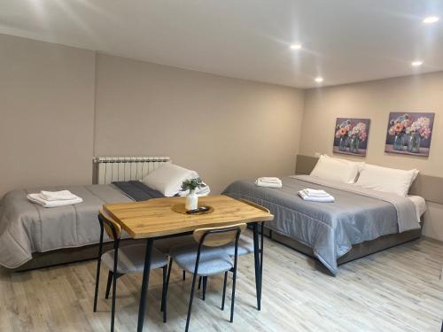 a room with two beds and a table and a table and chairs at Santa Caterina Apartament in Poggibonsi