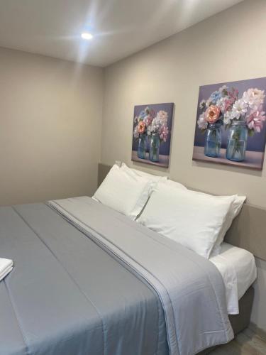 a bedroom with a bed with flowers in vases at Santa Caterina Apartament in Poggibonsi