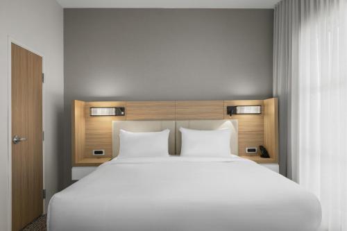 a large bed with two white pillows in a room at SpringHill Suites by Marriott Fort Collins in Fort Collins