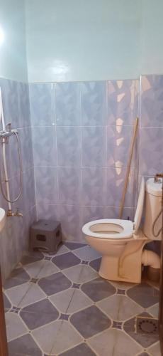 a bathroom with a toilet and a tiled floor at دار للكراء التضامن in Taroudant