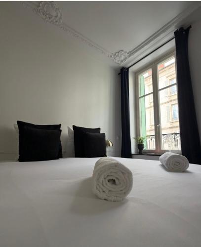 a bedroom with a white bed with a window at La suite du parc 1 in Nancy