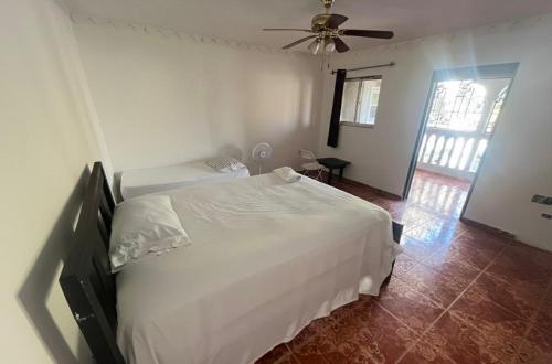 a bedroom with a white bed and a ceiling fan at Value guests in Magaeline