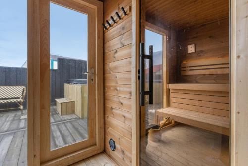 a wooden door leading to a sauna on a deck at Bryggjan Boutique Hotel in Akureyri
