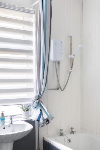 a bathroom with a shower and a sink and a window at Rotherham Kimberworth in Kimberworth