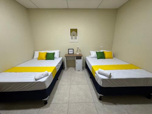 two twin beds in a room with a night stand at Ducky 1 in San Miguel