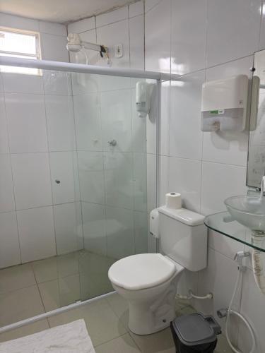 a white bathroom with a toilet and a shower at Hotel pousada Xique Xique in Piranhas