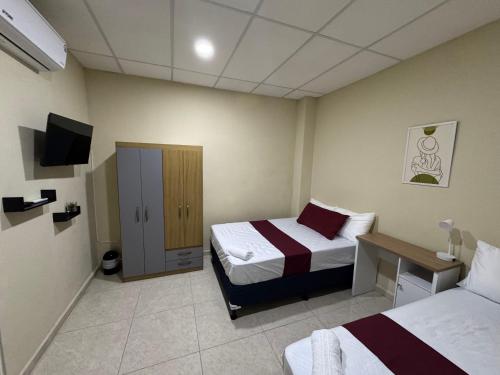 a hotel room with two beds and a television at Ducky4 in San Miguel