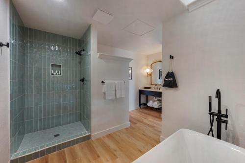 a bathroom with a shower and a tub and a sink at Hotel Dega in Bodega Bay