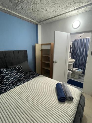 a bedroom with a bed and a bathroom with a toilet at Suite De Descanso En Urbanización Residencial FRENTE AL AEROPUERTO in Maiquetia