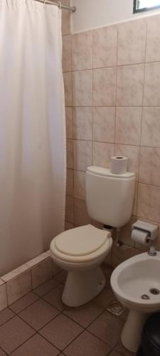 a bathroom with a toilet and a shower curtain at Posada La Maison D Agustine in Colón