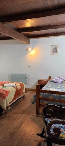 a bedroom with two beds and a wooden floor at Posada La Maison D Agustine in Colón