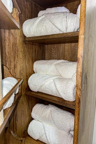 a bunch of white towels are on a shelf at Casa Bajareque in Cerro Punta