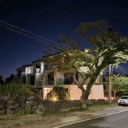 a house with a car parked in front of it at Jeju Teracehill Pension in Jeju