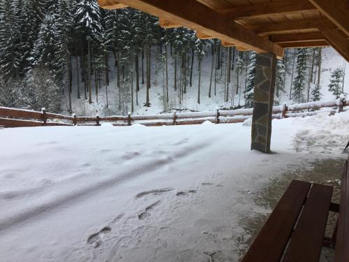 a snow covered yard with a bench and trees at Drevenica Vanesa in Terchová