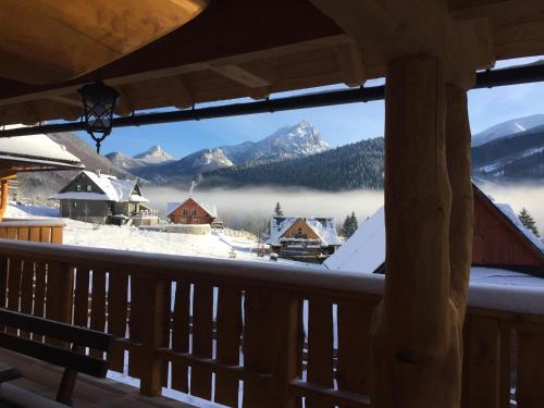 a view of a snowy mountain from a balcony at Drevenica Vanesa in Terchová