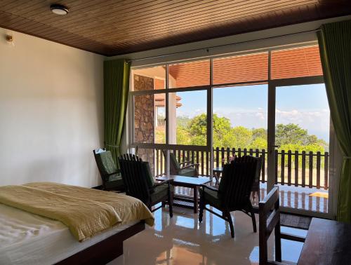 a bedroom with a bed and a balcony with a table and chairs at Ella Repose in Ella