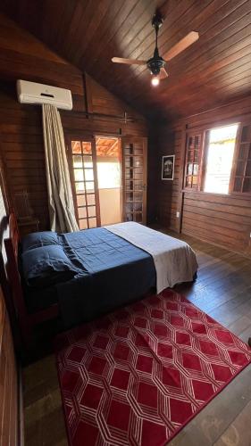 a bedroom with a bed in a wooden room at Casarão do Mar in Cabo Frio