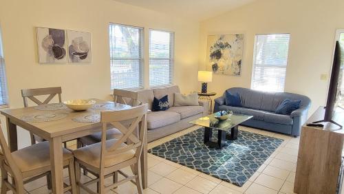 a living room with a table and a couch at Stylish House Near UF, VA, & Downtown Gainesville in Gainesville