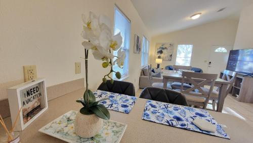 a living room with a table with a vase of flowers at Stylish House Near UF, VA, & Downtown Gainesville in Gainesville