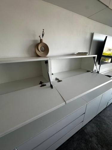 a white shelf with a vase sitting on top of it at Vista Haus in General Sarmiento