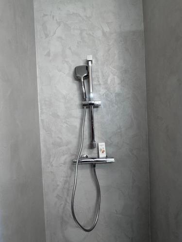 a bathroom with a blow dryer on a wall at maison romantique avec spa privé in Montargis