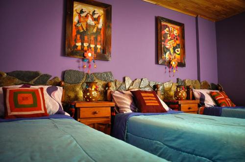 a room with two beds and paintings on the wall at Hostel Copacabana La Quiaca in La Quiaca