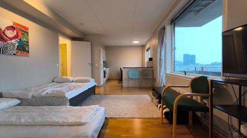 a room with two beds and a large window at Møllergata apartment in Oslo