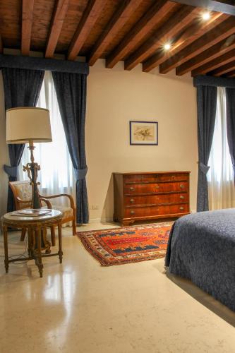 a bedroom with a bed and a table and a dresser at Sarai Apartments in Venice