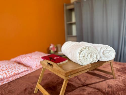 a pile of towels sitting on a wooden table next to a bed at Residence Cikaline Chambre d'hôte proximite du port de P-a-P in Pointe-à-Pitre