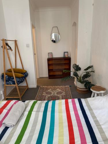 a bedroom with a bed with a colorful striped blanket at Cobble retreat high street in Hastings
