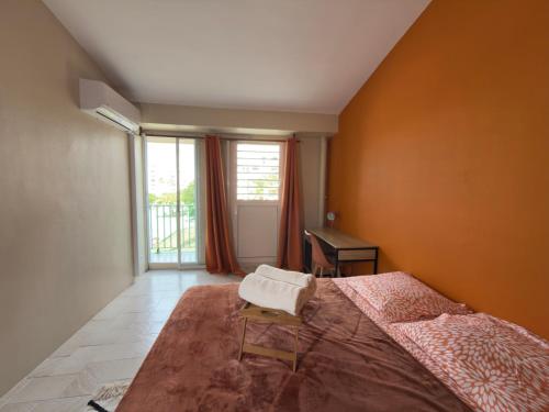 a bedroom with a large bed and a window at Residence Cikaline Chambre d'hôte proximite du port de P-a-P in Pointe-à-Pitre
