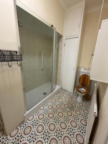 a bathroom with a shower and a toilet at Cobble retreat high street in Hastings