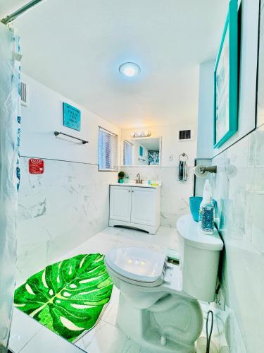 a bathroom with a toilet and a green leaf rug at Cozy Private Room with Shared Bathroom on the 1st Floor - Conveniently Located near SeaTac Airport and Downtown in Seattle