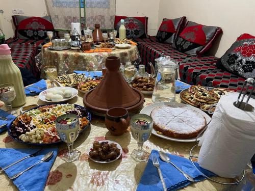 a table with many plates of food on it at Gite Boutferda in Bou Tferda