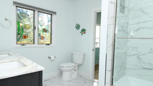 a bathroom with a toilet and a glass shower at 8 Bedrooms With A Pool - 404 Fourth Avenue in West Cape May
