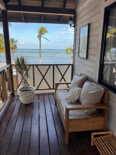 eine Couch auf einer Veranda mit Blick auf das Meer in der Unterkunft Alamar Hotel Boutique in Mahahual
