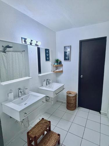 a bathroom with two sinks and a mirror at Escape Caribeño in Levittown