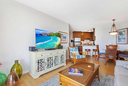 a living room with a flat screen tv on a cabinet at Penthouse Oceanview Vistas in Kihei
