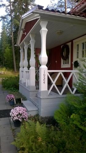 a small red and white house with a porch at Villa Tammikko in Tuusula