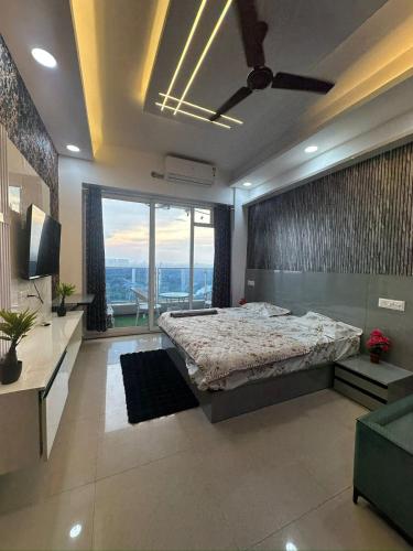 a bedroom with a bed and a large window at Luxury studios in Ghaziabad