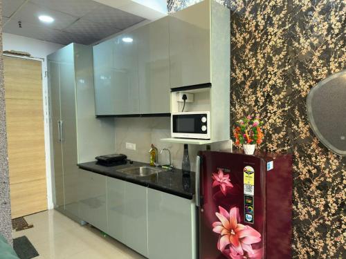 a kitchen with a refrigerator and a microwave at Luxury studios in Ghaziabad