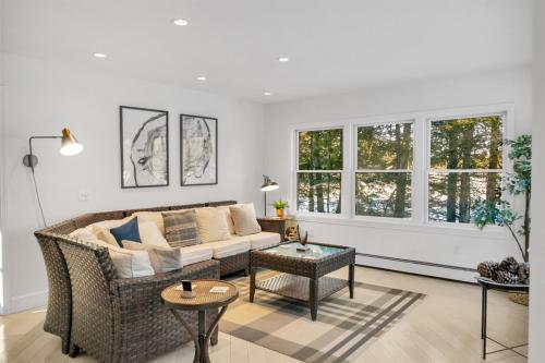a living room with a couch and two windows at Northern Nest MDI Lakefront Single-Level, Dual King Bedrooms & Private Dock in Pretty Marsh